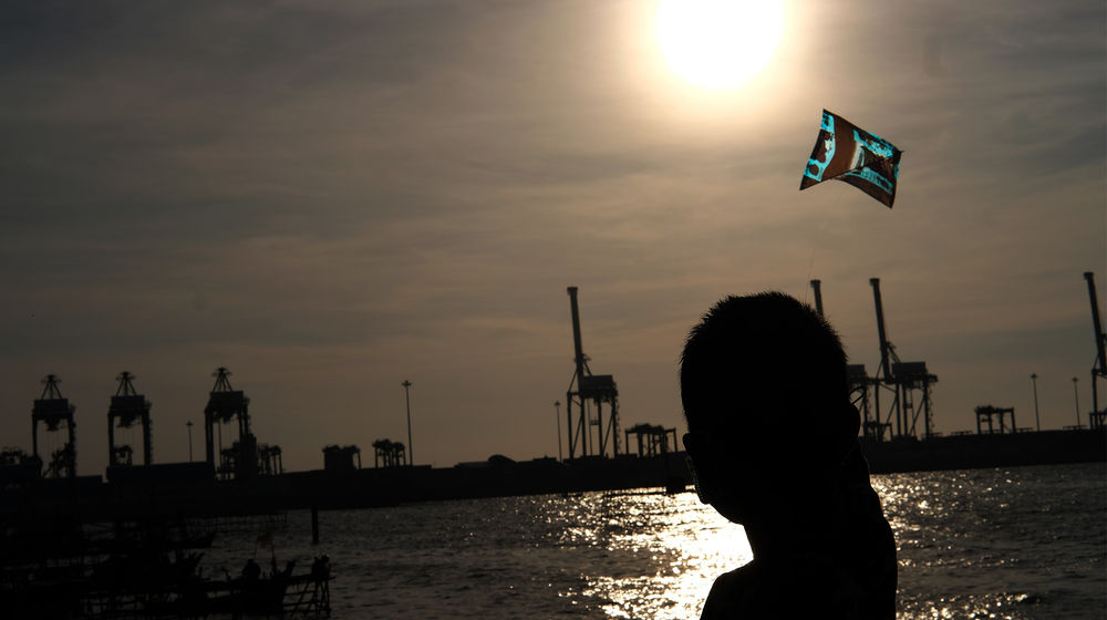 <p>Seorang anak bermain layang-layang di perkampungan nelayan kawasan Cilincing, Jakarta Utara, Minggu, 26 Juli 2020. Warga dan nelayan mengaku dampak pembatasan sosial berskala besar (PSBB) akibat pandemi COVID-19 sangat berpengaruh terhadap perekonomian warga pesisir Jakarta Utara. Harga jual hasil laut nelayan merosot tajam, seperti harga jual ikan berkurang hingga setengah harga normal. Foto: Ismail Pohan/TrenAsia</p>
