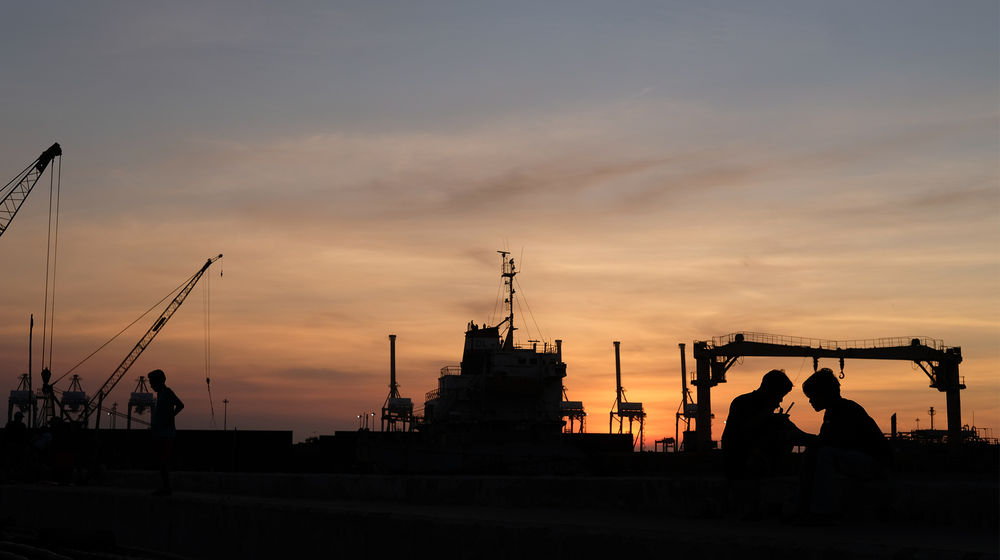 <p>Siluet warga beraktivitas di perkampungan nelayan kawasan Cilincing, Jakarta Utara, Minggu, 26 Juli 2020. Warga dan nelayan mengaku dampak pembatasan sosial berskala besar (PSBB) akibat pandemi COVID-19 sangat berpengaruh terhadap perekonomian warga pesisir Jakarta Utara. Harga jual hasil laut nelayan merosot tajam, seperti harga jual ikan berkurang hingga setengah harga normal. Foto: Ismail Pohan/TrenAsia</p>
