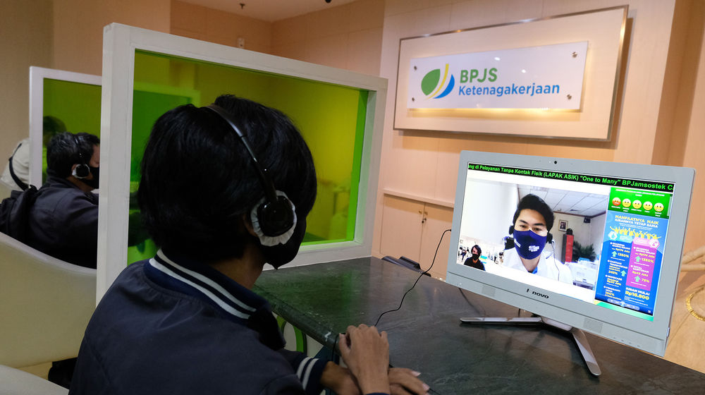 <p>Peserta BP Jamsostek berkomunikasi dengan petugas pelayanan saat melakukan klaim melalui Layanan Tanpa Kontak Fisik (Lapak Asik) di kantor Cabang Jakarta Menara Jamsostek, Jakarta, Jum’at, 10 Juli 2020. Seiring dengan meningkatnya gelombang pemutusan hubungan kerja di tengah pandemi Covid-19, klaim BPJS Ketenagakerjaan turut melonjak. Pencairan tabungan di BP Jamsostek menjadi alternatif untuk mendukung daya beli pekerja yang tergerus. Sementara dalam rangka adaptasi kebiasaan baru dan untuk memutus penyebaran virus corona, BP Jamsostek telah menerapkan protokol pelayanan secara daring dan tanpa pertemuan secara fisik. Foto: Ismail Pohan/TrenAsia</p>
