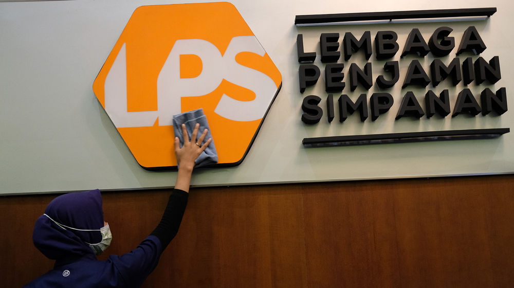 <p>Karyawan membersihkan logo Lembaga Penjamin Simpanan (LPS) di Jakarta, Jum’at, 10 Juli 2020.  Lembaga Penjamin Simpanan (LPS) diberikan kewenangan tambahan berupa penyelamatan bank sakit dan penempatan dana pada bank yang kesulitan likuiditas selama pandemi Covid-19. Penempatan dana oleh LPS tersebut bertujuan untuk mengelola dan/atau meningkatkan likuiditas LPS, serta mengantisipasi dan/atau melakukan penanganan stabilitas permasalahan sistem keuangan yang dapat menyebabkan kegagalan bank. Kewenangan tersebut diatur dalam Peraturan Pemerintah No.33/2020 yang mengatur mengenai Pelaksanaan Kewenangan LPS. Foto: Ismail Pohan/TrenAsia</p>
