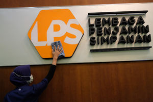 <p>Karyawan membersihkan logo Lembaga Penjamin Simpanan (LPS) di Jakarta, Jum’at, 10 Juli 2020. Lembaga Penjamin Simpanan (LPS) diberikan kewenangan tambahan berupa penyelamatan bank sakit dan penempatan dana pada bank yang kesulitan likuiditas selama pandemi Covid-19. Penempatan dana oleh LPS tersebut bertujuan untuk mengelola dan/atau meningkatkan likuiditas LPS, serta mengantisipasi dan/atau melakukan penanganan stabilitas permasalahan sistem keuangan yang dapat menyebabkan kegagalan bank. Kewenangan tersebut diatur dalam Peraturan Pemerintah No.33/2020 yang mengatur mengenai Pelaksanaan Kewenangan LPS. Foto: Ismail Pohan/TrenAsia</p>