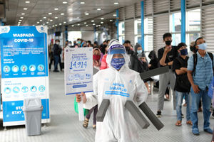 <p>Maskot ‘Manusia Covid’ dari anggota komunitas pecinta Transjakarta mengenakan hazmat dengan membawa poster berisi informasi jumlah kasus positif di Jakarta saat melakukan sosialisasi protokol kesehatan di Halte Transjakarta Harmoni, Jakarta, Rabu, 15 Juli 2020. Sosialisasi tersebut untuk mengingatkan penumpang Transjakarta agar selalu menaati protokol kesehatan saat menggunakan transportasi publik untuk memutus rantai penyebaran COVID-19. Foto: Ismail Pohan/TrenAsia</p>