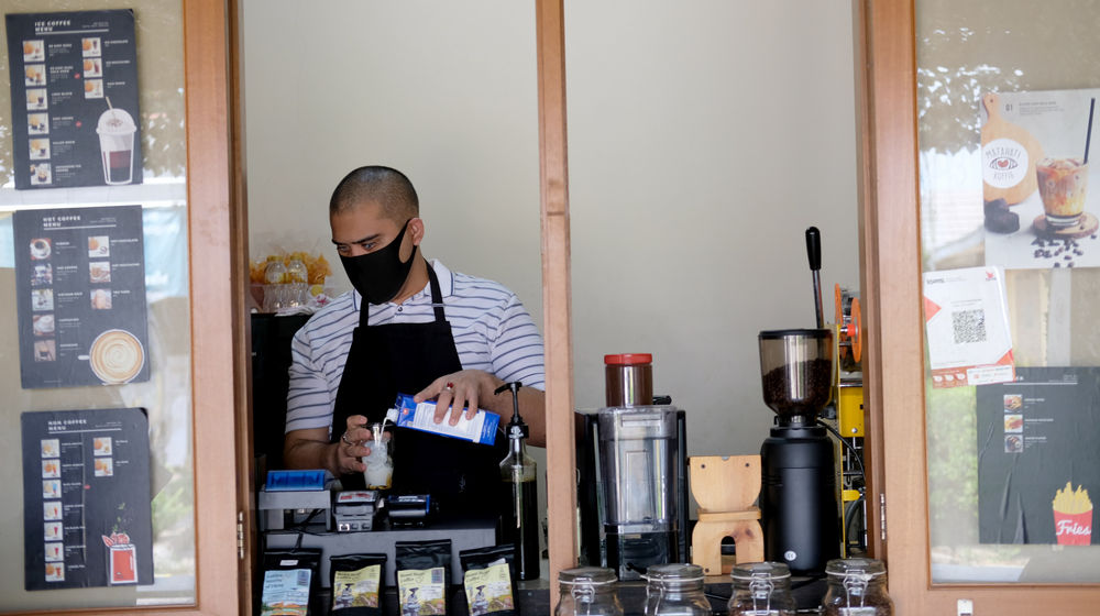 <p>Ahmad Hilmy Almusawa (22) penyandang tuna netra menyiapkan pesanan kopi untuk pelanggan di gerainya “Mata Hati Koffie”, kawasan Pondok Cabe, Tangerang Selatan, Kamis, 23 Juli 2020. Meski dalam situasi pandemi, Hilmy yang sudah mengalami kebutaan sejak umur 12 tahun ini tetap semangat meracik kopi dengan hati di gerai miliknya sendiri tersebut. Omset yang menurun tidak serta merta menurunkan semangatnya untuk tetap menjalankan bisnisnya dengan sepenuh hati melayani setiap penikmat kopi yang datang tak terkecuali pelanggan setianya. Foto: Ismail Pohan/TrenAsia</p>
