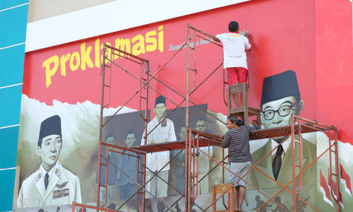 <p>Seniman mengerjakan pembuatan mural bertemakan Proklamasi di Sekolah Dasar Negeri (SDN) Pondok Aren 02, Tangerang Selatan, Banten, Rabu, 22 Juli 2020. Mural tersebut dibuat dalam rangka menyambut  HUT  ke-75 RI tahun ini yang mengusung tema &#8220;Indonesia Maju&#8221;. Namun karena masih berada dalam situasi pandemi COVID-19, pemerintah menyerukan agar peringatan digelar secara sederhana dengan tetap menerapkan protokol kesehatan kenormalan baru. Foto: Ismail Pohan/TrenAsia</p>
