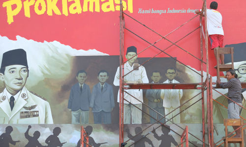 <p>Seniman mengerjakan pembuatan mural bertemakan Proklamasi di Sekolah Dasar Negeri (SDN) Pondok Aren 02, Tangerang Selatan, Banten, Rabu, 22 Juli 2020. Mural tersebut dibuat dalam rangka menyambut  HUT  ke-75 RI tahun ini yang mengusung tema &#8220;Indonesia Maju&#8221;. Namun karena masih berada dalam situasi pandemi COVID-19, pemerintah menyerukan agar peringatan digelar secara sederhana dengan tetap menerapkan protokol kesehatan kenormalan baru. Foto: Ismail Pohan/TrenAsia</p>
