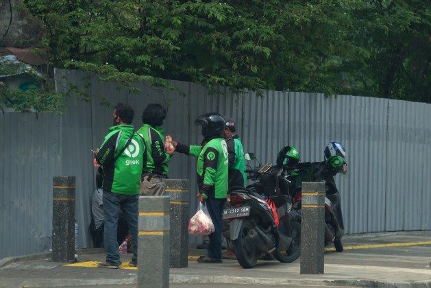 <p>Sejumlah Driver Ojek Online menunggu orderan di Jakarta, Jumat (10/4/2020). Peraturan Gubernur DKI Jakarta dalam pelaksanaan PSBB mengatur angkutan roda dua seperti ojek online maupun ojek konvensional dilarang membawa penumpang. Foto: Ismail Pohan/TrenAsia</p>
