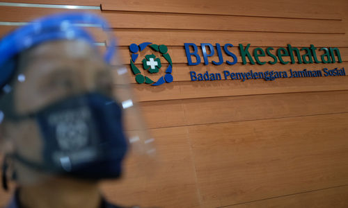 <p>Karyawan beraktivitas di dekat logo BPJS Kesehatan di Jakarta, Selasa, 14 Juni 2020. BPJS Kesehatan menyatakan telah menuntaskan pembayaran klaim rumah sakit per 1 Juli sebesar Rp3,70 triliun seiring awal bulan Juli BPJS Kesehatan telah menerima iuran peserta Penerima Iuran Bantuan (PIB) APBN dari pemerintah sebesar Rp4,05 triliun. Foto: Ismail Pohan/TrenAsia</p>

