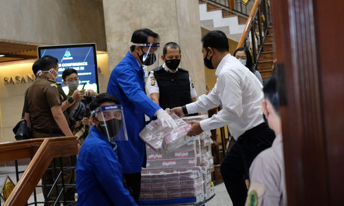 <p>Petugas kejaksaan menurunkan barang bukti uang sitaan dalam konferensi pers di Kantor Kejaksaan Agung, Jakarta, Selasa, 7 Juli 2020. Tersangka korporasi kasus Jiwasraya, PT Sinarmas Asset Management mengembalikan kerugian negara senilai Rp 77 miliar ke Kejaksaan Agung (Kejagung) dalam dua tahap, tahap pertama sekitar Rp 3 miliar dan hari ini senilai Rp 74 miliar sebagai bagian dari penyelesaian perkara terkait dengan penyidikan Jiwasraya. Foto: Ismail Pohan/TrenAsia</p>
