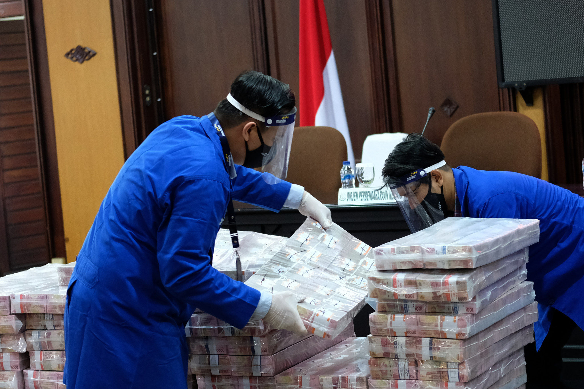 <p>Petugas mempersiapkan barang bukti uang sitaan dalam konferensi pers di Kantor Kejaksaan Agung, Jakarta, Selasa, 7 Juli 2020.  Foto: Ismail Pohan/TrenAsia</p>
