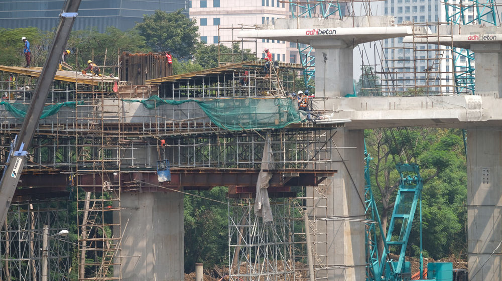 <p>Suasana pengerjaan jalur kereta ringan (LRT) Jakarta jurusan Cawang-Dukuh Atas di samping Waduk Setiabudi, Jakarta, Rabu, 22 Juli 2020. Hingga awal Juli 2020, pengerjaan proyek mencapai 72,51 persen atau bertambah 1 persen dari bulan sebelumnya. LRT Jabodebek nantinya akan terkoneksi dengan kawasan terpadu TOD yang menggabungkan transportasi MRT, Kereta Commuter Line, dan bus TransJakarta yang ditargerkan siap beroperasi secara komersial pada Juni 2022. Foto: Ismail Pohan/TrenAsia</p>
