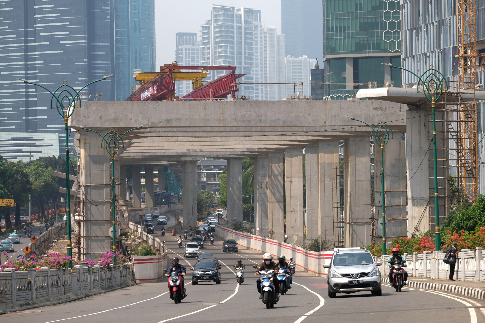 <p>Suasana pengerjaan jalur kereta ringan (LRT) Jakarta jurusan Cawang-Dukuh Atas di samping Waduk Setiabudi, Jakarta, Rabu, 22 Juli 2020. Hingga awal Juli 2020, pengerjaan proyek mencapai 72,51 persen atau bertambah 1 persen dari bulan sebelumnya. LRT Jabodebek nantinya akan terkoneksi dengan kawasan terpadu TOD yang menggabungkan transportasi MRT, Kereta Commuter Line, dan bus TransJakarta yang ditargerkan siap beroperasi secara komersial pada Juni 2022. Foto: Ismail Pohan/TrenAsia</p>
