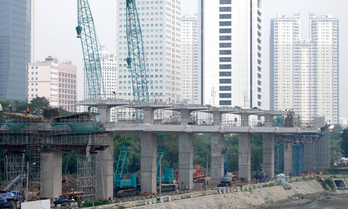 <p>Suasana pengerjaan jalur kereta ringan (LRT) Jakarta jurusan Cawang-Dukuh Atas di samping Waduk Setiabudi, Jakarta, Rabu, 22 Juli 2020. Hingga awal Juli 2020, pengerjaan proyek mencapai 72,51 persen atau bertambah 1 persen dari bulan sebelumnya. LRT Jabodebek nantinya akan terkoneksi dengan kawasan terpadu TOD yang menggabungkan transportasi MRT, Kereta Commuter Line, dan bus TransJakarta yang ditargerkan siap beroperasi secara komersial pada Juni 2022. Foto: Ismail Pohan/TrenAsia</p>
