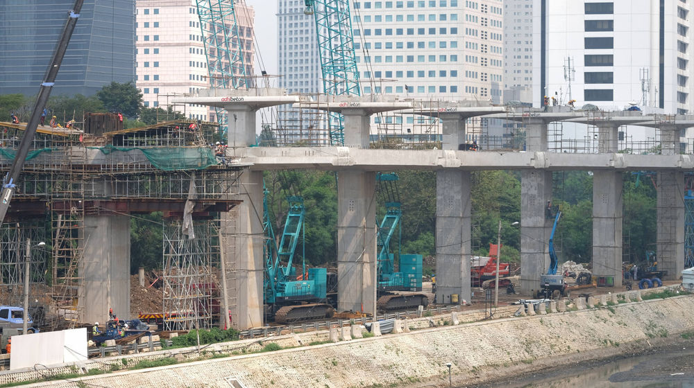 <p>Suasana pengerjaan jalur kereta ringan (LRT) Jakarta jurusan Cawang-Dukuh Atas di samping Waduk Setiabudi, Jakarta, Rabu, 22 Juli 2020. Hingga awal Juli 2020, pengerjaan proyek mencapai 72,51 persen atau bertambah 1 persen dari bulan sebelumnya. LRT Jabodebek nantinya akan terkoneksi dengan kawasan terpadu TOD yang menggabungkan transportasi MRT, Kereta Commuter Line, dan bus TransJakarta yang ditargerkan siap beroperasi secara komersial pada Juni 2022. Foto: Ismail Pohan/TrenAsia</p>
