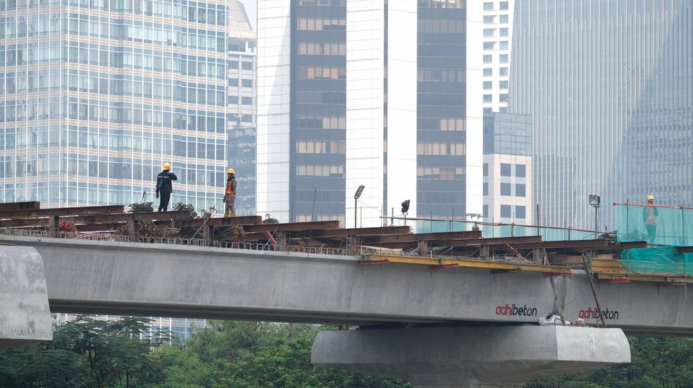 <p>Suasana pengerjaan jalur kereta ringan (LRT) Jakarta jurusan Cawang-Dukuh Atas di samping Waduk Setiabudi, Jakarta, Rabu, 22 Juli 2020. Hingga awal Juli 2020, pengerjaan proyek mencapai 72,51 persen atau bertambah 1 persen dari bulan sebelumnya. LRT Jabodebek nantinya akan terkoneksi dengan kawasan terpadu TOD yang menggabungkan transportasi MRT, Kereta Commuter Line, dan bus TransJakarta yang ditargerkan siap beroperasi secara komersial pada Juni 2022. Foto: Ismail Pohan/TrenAsia</p>
