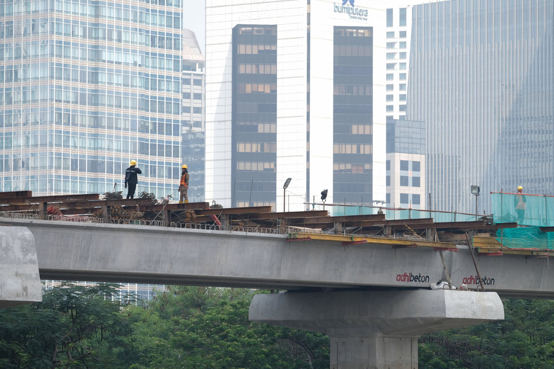 <p>Suasana pengerjaan jalur kereta ringan (LRT) Jakarta jurusan Cawang-Dukuh Atas di samping Waduk Setiabudi, Jakarta, Rabu, 22 Juli 2020. Hingga awal Juli 2020, pengerjaan proyek mencapai 72,51 persen atau bertambah 1 persen dari bulan sebelumnya. LRT Jabodebek nantinya akan terkoneksi dengan kawasan terpadu TOD yang menggabungkan transportasi MRT, Kereta Commuter Line, dan bus TransJakarta yang ditargerkan siap beroperasi secara komersial pada Juni 2022. Foto: Ismail Pohan/TrenAsia</p>
