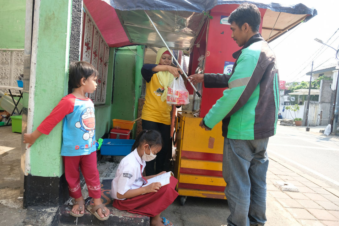 <p>Keysha (8) mengikuti pelajaran secara online sementara ibundanya melayani pembeli di gerai ayam krispy tempat ibunya bekerja, di Jalan Bukit Duri Tanjakan, Gang Langgar, Jakarta Selatan, Selasa, 28 Juli 2020. Foto: Ismail Pohan/TrenAsia</p>
