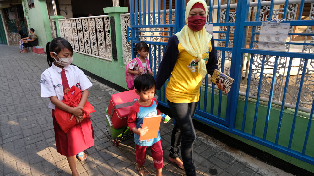 <p>Keysha (8) berjalan bersama ibunda dan adiknya untuk mengikuti pelajaran secara online di gerai ayam krispy tempat ibunya bekerja, di Jalan Bukit Duri Tanjakan, Gang Langgar, Jakarta Selatan, Selasa, 28 Juli 2020. Anak pertama dari tiga bersaudara pasangan Firman (32) dan Okta (31) tampak tekun mengikuti pelajaran berbasis online di masa kernormalan baru saat ini. Keluarga yang terdampak secara ekonomi akibat  ayahnya yang dirumahkan dari pekerjaan, membuat ibunya harus turun tangan dengan bekerja di gerai ayam krispy milik tetangga mereka. Belum lagi sistem sekolah online yang memaksa orang tua Keysha harus menyisihkan penghasilan untuk membeli pulsa Rp 25000 per minggu agar anak mereka dapat terus belajar. Ditengah himpitan ekonomi, Keysha yang bercita-cita menjadi seorang dokter ini terus memupuk semangatnya untuk belajar agar bisa membanggakan keluarga, sembari berdoa agar ayahnya kembali mendapatkan pekerjaan dan badai corona segera berakhir. Foto: Ismail Pohan/TrenAsia</p>

