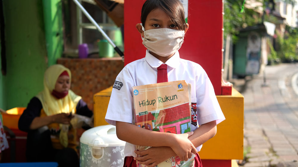 <p>Keysha (8) berpose sebelum mengikuti pelajaran secara online di gerai ayam krispy tempat ibunya bekerja, di Jalan Bukit Duri Tanjakan, Gang Langgar, Jakarta Selatan, Selasa, 28 Juli 2020. Anak pertama dari tiga bersaudara pasangan Firman (32) dan Okta (31) tampak tekun mengikuti pelajaran berbasis online di masa kernormalan baru saat ini. Keluarga yang terdampak secara ekonomi akibat  ayahnya yang dirumahkan dari pekerjaan, membuat ibunya harus turun tangan dengan bekerja di gerai ayam krispy milik tetangga mereka. Belum lagi sistem sekolah online yang memaksa orang tua Keysha harus menyisihkan penghasilan untuk membeli pulsa Rp 25000 per minggu agar anak mereka dapat terus belajar. Ditengah himpitan ekonomi, Keysha yang bercita-cita menjadi seorang dokter ini terus memupuk semangatnya untuk belajar agar bisa membanggakan keluarga, sembari berdoa agar ayahnya kembali mendapatkan pekerjaan dan badai corona segera berakhir. Foto: Ismail Pohan/TrenAsia</p>
