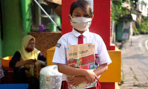 <p>Keysha (8) berpose sebelum mengikuti pelajaran secara online di gerai ayam krispy tempat ibunya bekerja, di Jalan Bukit Duri Tanjakan, Gang Langgar, Jakarta Selatan, Selasa, 28 Juli 2020. Anak pertama dari tiga bersaudara pasangan Firman (32) dan Okta (31) tampak tekun mengikuti pelajaran berbasis online di masa kernormalan baru saat ini. Keluarga yang terdampak secara ekonomi akibat ayahnya yang dirumahkan dari pekerjaan, membuat ibunya harus turun tangan dengan bekerja di gerai ayam krispy milik tetangga mereka. Belum lagi sistem sekolah online yang memaksa orang tua Keysha harus menyisihkan penghasilan untuk membeli pulsa Rp 25000 per minggu agar anak mereka dapat terus belajar. Ditengah himpitan ekonomi, Keysha yang bercita-cita menjadi seorang dokter ini terus memupuk semangatnya untuk belajar agar bisa membanggakan keluarga, sembari berdoa agar ayahnya kembali mendapatkan pekerjaan dan badai corona segera berakhir. Foto: Ismail Pohan/TrenAsia</p>