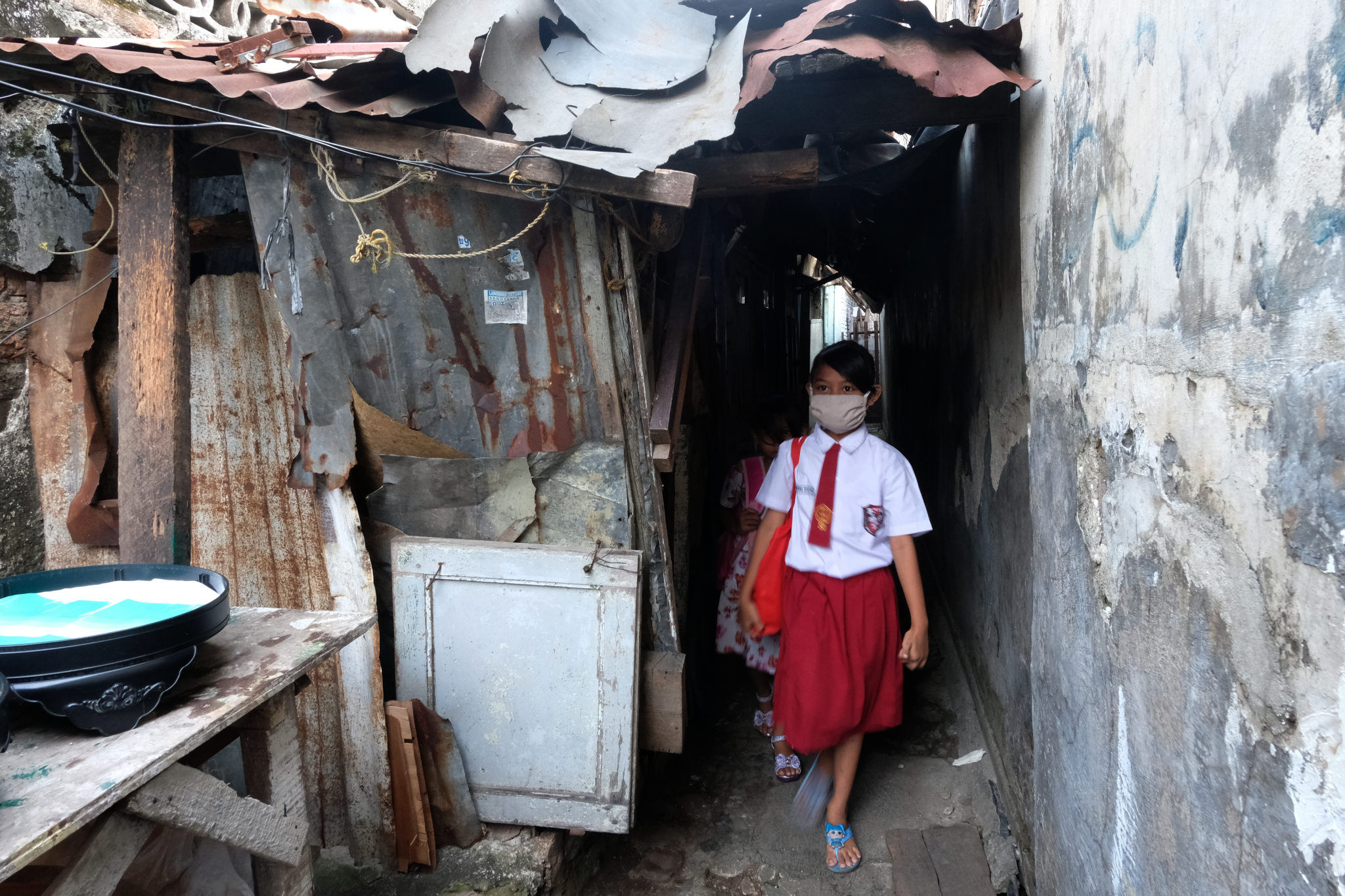 <p>Keysha (8) berjalan dari rumahnya untuk mengikuti pelajaran secara online di gerai ayam krispy tempat ibunya bekerja, di Jalan Bukit Duri Tanjakan, Gang Langgar, Jakarta Selatan, Selasa, 28 Juli 2020. Anak pertama dari tiga bersaudara pasangan Firman (32) dan Okta (31) tampak tekun mengikuti pelajaran berbasis online di masa kernormalan baru saat ini. Keluarga yang terdampak secara ekonomi akibat  ayahnya yang dirumahkan dari pekerjaan, membuat ibunya harus turun tangan dengan bekerja di gerai ayam krispy milik tetangga mereka. Belum lagi sistem sekolah online yang memaksa orang tua Keysha harus menyisihkan penghasilan untuk membeli pulsa Rp 25000 per minggu agar anak mereka dapat terus belajar. Ditengah himpitan ekonomi, Keysha yang bercita-cita menjadi seorang dokter ini terus memupuk semangatnya untuk belajar agar bisa membanggakan keluarga, sembari berdoa agar ayahnya kembali mendapatkan pekerjaan dan badai corona segera berakhir. Foto: Ismail Pohan/TrenAsia</p>
