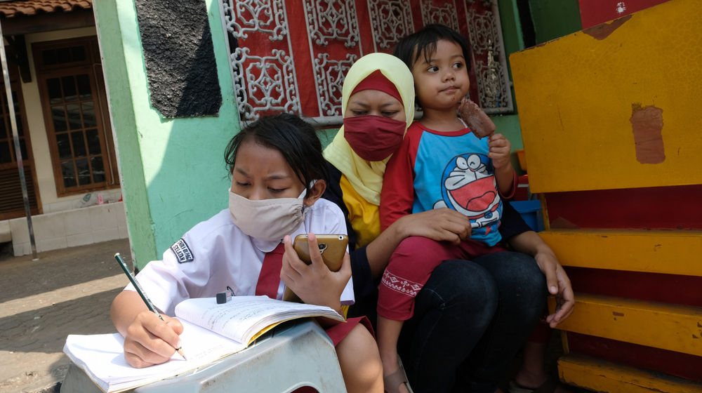<p>Keysha (8) mengikuti pelajaran secara online didampingi ibundanya di gerai ayam krispy tempat ibunya bekerja, di Jalan Bukit Duri Tanjakan, Gang Langgar, Jakarta Selatan, Selasa, 28 Juli 2020. Foto: Ismail Pohan/TrenAsia</p>
