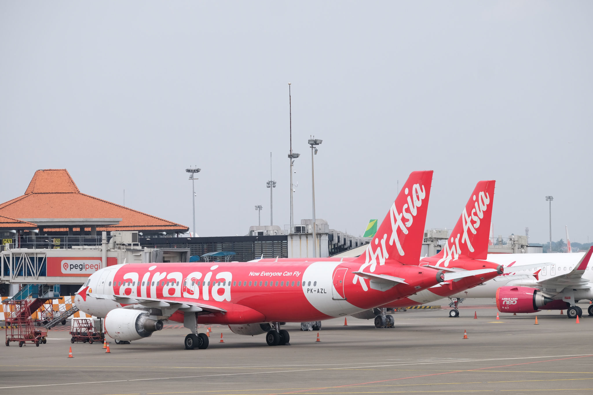 <p>Maskapai penerbangan komersil Air Asia tampak terparkir di Bandara Soekarno Hatta, Tangerang, Banten, Jum&#8217;at, 3 Juni 2020. PT Angkasa Pura II (Persero) akan mengkordinasikan permintaan maskapai untuk slot penerbangan, rute penerbangan dan frekuensi penerbangan di dalam satu rute agar kembali terciptanya keseimbangan terhadap tingkat permintaan dari penumpang, saat ini PT Angkasa Pura II mengaku slot terbang di Bandara Soekarno Hatta belum optimal dimanfaatkan oleh maskapai pada masa new normal ini. Foto: Ismail Pohan/TrenAsia</p>
