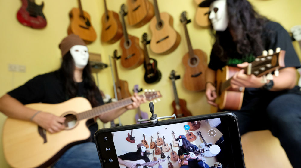 <p>Pemilik showroom dan bengkel Gitar “music666”, Ridwan (kiri) dan Rudi (kanan) mendemonstrasikan gitar yang akan dijual secara daring di  Ciledug, Tangerang, Banten, Rabu 22 Juli 2020. Kementerian Koordinator Bidang Kemaritiman dan Investasi terus mendorong 10 juta Usaha Mikro Kecil Menengah (UMKM) terhubung dengan platform digital atau “go online” hingga akhir tahun ini. Perubahan tren dan perilaku konsumen dengan membatasi interaksi fisik dan mengurangi aktivitas di luar rumah terbukti dapat memberi peluang lebih besar kepada UMKM yang sudah terhubung dengan ekosistem digital untuk bertahan atau bahkan melaju di pandemi COVID-19. Foto: Ismail Pohan/TrenAsia</p>
