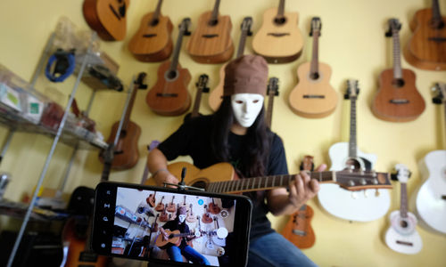 <p>Pemilik showroom dan bengkel Gitar “music666”, Ridwan mendemonstrasikan gitar yang akan dijual secara daring di Ciledug, Tangerang, Banten, Rabu 22 Juli 2020. Kementerian Koordinator Bidang Kemaritiman dan Investasi terus mendorong 10 juta Usaha Mikro Kecil Menengah (UMKM) terhubung dengan platform digital atau “go online” hingga akhir tahun ini. Perubahan tren dan perilaku konsumen dengan membatasi interaksi fisik dan mengurangi aktivitas di luar rumah terbukti dapat memberi peluang lebih besar kepada UMKM yang sudah terhubung dengan ekosistem digital untuk bertahan atau bahkan melaju di tengah pandemi COVID-19. Foto: Ismail Pohan/TrenAsia</p>