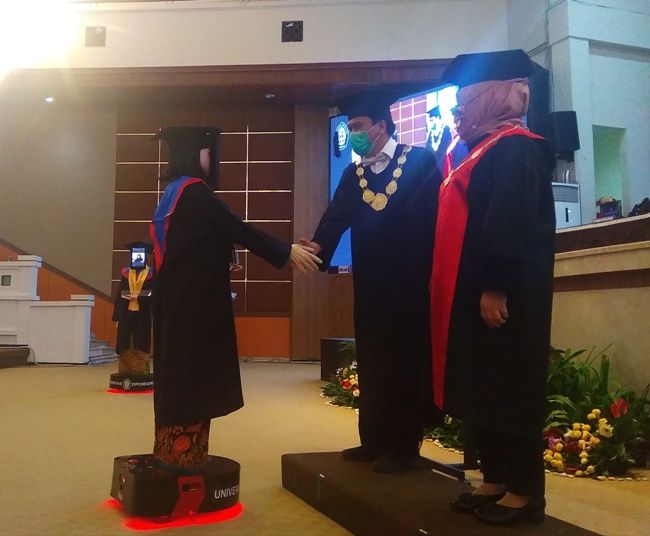 <p>Robot-robot wisudawan berjabat tangan dengan Rektor Undip Yos Johan Utama, seusai menerima ijazah. / Istimewa.</p>
