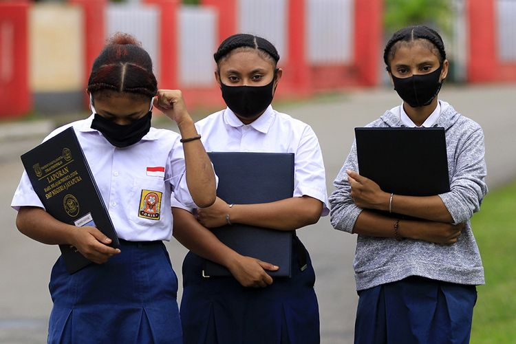 siswa pergi ke sekolah dengan menggunakan masker