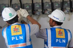 Petugas PLN sedang mencatat meteran listrik di rumah warga.