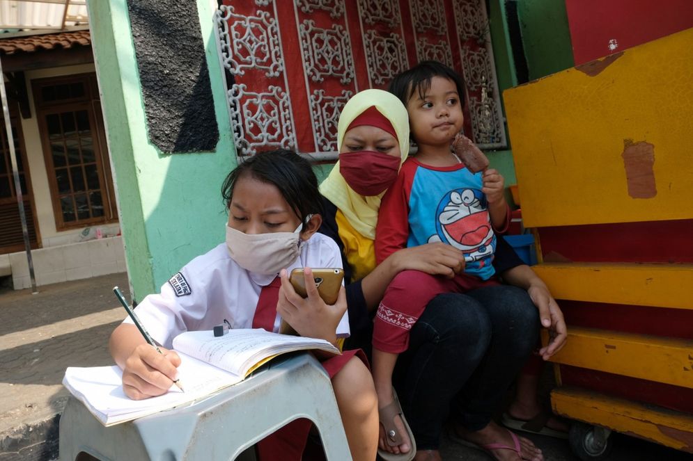 Keysha (8) mengikuti pelajaran secara online didampingi ibundanya di gerai ayam krispy tempat ibunya bekerja, di Jalan Bukit Duri Tanjakan, Gang Langgar, Jakarta Selatan, Selasa, 28 Juli 2020. Foto: Ismail Pohan/TrenAsia