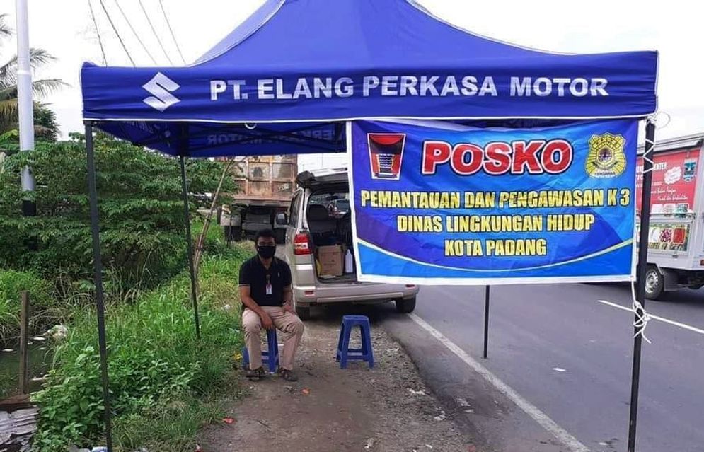 Seorang petugas DLH tengah berada di Posko Pemantuan dan Pengawasan K3 di Simpang Taruko Kuranji Padang/Foto: ist