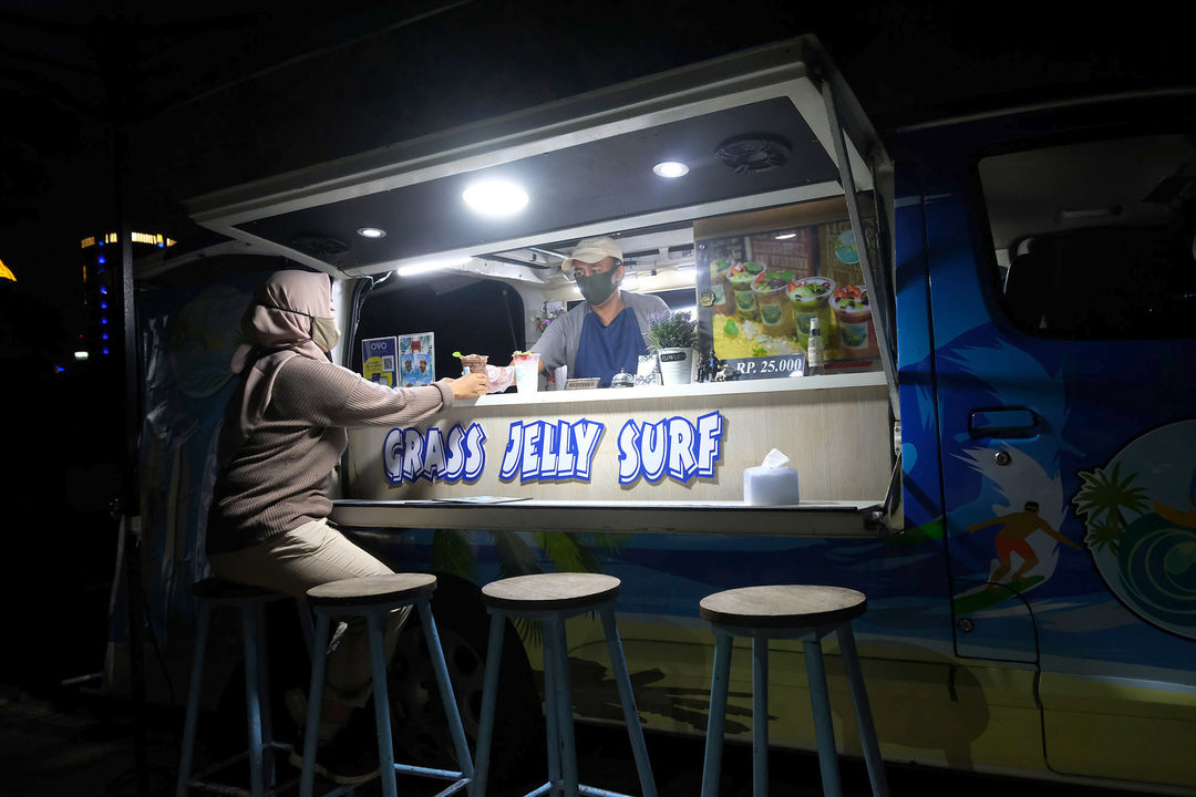 <p>Berni (47) bersama istrinya Arianti (36) berada di gerai foodtruck &#8220;Grass Jelly Surf&#8221; miliknya yang menjual minuman segar di area perkantoran Cibis Park, kawasan TB Simatupang, Jakarta Selatan, Kamis, 13 Agustus 2020. Bisnis yang sudah dirintis selama 6 tahun ini, masih berusaha bertahan ditengah hantaman pandemi. Sepinya event dan kegiatan komunitas foodtruck membuat Berni harus rela kehilangan omset yang selama ini diraup dari hasil usahanya yang termasuk dalam Usaha Mikro Kecil Menengah (UMKM) mitra binaan Pertamina tersebut. Pria yang berlatar belakang Chef di sebuah kapal pesiar selama 2 tahun ini, berharap pemerintah khususnya wadah binaan seperti Pertamina bisa memberikan perhatian khusus kepada pelaku UMKM yang terdampak pandemi Covid-19 untuk tetap hidup di bidang usahanya dengan bantuan yang nyata menyasar pada suplai produk yang mereka pasarkan. Karena selama ini mereka hanya gencar ditawarkan bantuan berupa pinjaman dana yang justru dianggap semakin menambah beban kedepannya. Foto: Ismail Pohan/TrenAsia</p>
