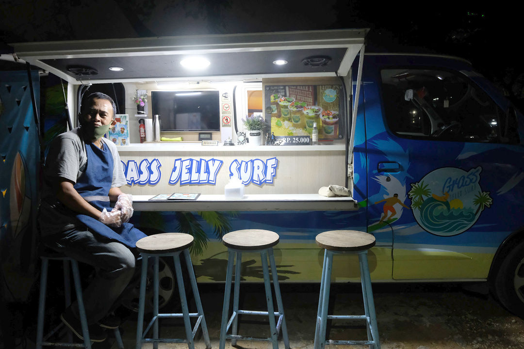 <p>Berni (47) berpose didepan gerai foodtruck &#8220;Grass Jelly Surf&#8221; miliknya yang menjual minuman segar di area perkantoran Cibis Park, kawasan TB Simatupang, Jakarta Selatan, Kamis, 13 Agustus 2020. Bisnis yang sudah dirintis selama 6 tahun ini, masih berusaha bertahan ditengah hantaman pandemi. Sepinya event dan kegiatan komunitas foodtruck membuat Berni harus rela kehilangan omset yang selama ini diraup dari hasil usahanya yang termasuk dalam Usaha Mikro Kecil Menengah (UMKM) mitra binaan Pertamina tersebut. Pria yang berlatar belakang Chef di sebuah kapal pesiar selama 2 tahun ini, berharap pemerintah khususnya wadah binaan seperti Pertamina bisa memberikan perhatian khusus kepada pelaku UMKM yang terdampak pandemi Covid-19 untuk tetap hidup di bidang usahanya dengan bantuan yang nyata menyasar pada suplai produk yang mereka pasarkan. Karena selama ini mereka hanya gencar ditawarkan bantuan berupa pinjaman dana yang justru dianggap semakin menambah beban kedepannya. Foto: Ismail Pohan/TrenAsia</p>
