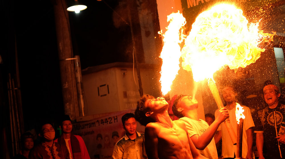 <p>Warga menunjukkan atraksi sembur api saat peringatan malam 1 Muharram 1442 H di kawasan Rempoa, Ciputat, Tangerang Selatan, Banten, Rabu, 19 Agustus 2020 malam. Kegiatan Gema Muharram tersebut diisi dengan berbagai kegiatan lomba, pawai obor dan permainan tradisional sepakbola api yang rutin diadakan warga untuk menjaga kerukunan dan menyambut pergantian Tahun Baru Islam. Foto: Ismail Pohan/TrenAsia</p>
