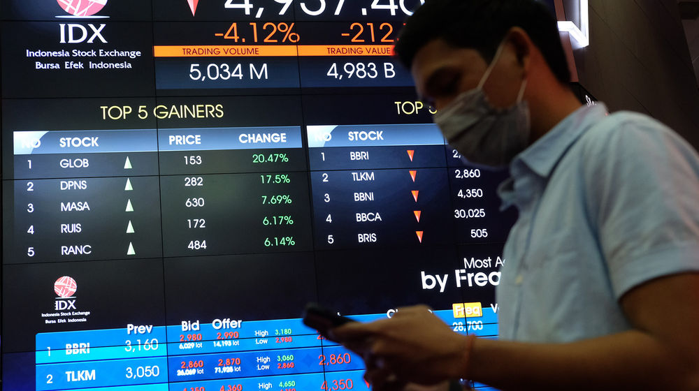 <p>Awak media beraktivitas dengan latar belakang monitor pergerakan Indeks Harga Saham Gabungan (IHSG) di gedung Bursa Efek Indonesia (BEI), Jakarta, Senin, 3 Agustus 2020. Indeks Harga Saham Gabungan (IHSG) ditutup melemah 2,78 persen atau 143,4 poin ke level 5.006,22 pada akhir sesi Senin (3/8/2020), setelah bergerak di rentang 4.928,47 – 5.157,27. Artinya, indeks sempat anjlok 4 persen dan terlempar dari zona 5.000. Risiko penurunan data perekonomian kawasan Asean termasuk Indonesia menjadi penyebab (IHSG) terkoreksi cukup dalam hari ini. Foto: Ismail Pohan/TrenAsia</p>
