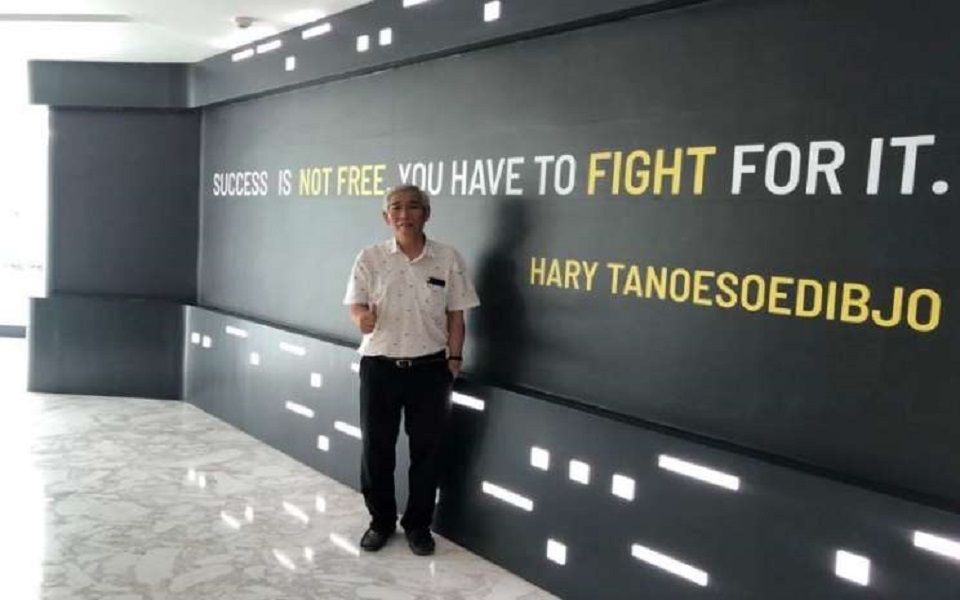 Investor saham kawakan Lo Kheng Hong berpose di depan tulisan kata mutiara dari Hary Tanoesoedibjo. (Foto: Istimewa)
