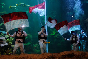 <p>Sejumlah penyelam mengibarkan Bendera Merah Putih saat upacara pengibaran Bendera Peringatan HUT ke-75 RI di Akuarium Utama Sea Word, Ancol, Jakarta, Senin, 17 Agustus 2020. Pengibaran Bendera Merah Putih dan Pembacaan Teks Proklamasi oleh empat orang penyelam profesional Sea Word Ancol tersebut berlangsung hikmat untuk memperingati Hari Kemerdekaan RI. Foto: Ismail Pohan/TrenAsia</p>
