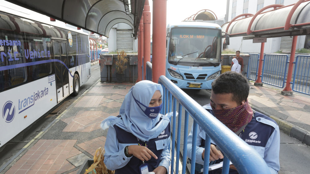 <p>Petugas Transjakarta berbincang diantara koridor Bus Terminal Blok M, Jakarta, Rabu, 5 Agustus 2020. Pemerintah masih berupaya keras memulihkan aktivitas transportasi di masa adaptasi kebiasaan baru (AKB), karena akibat pandemi masyarakat masih berwaspada menggunakan angkutan umum. Kementerian Perhubungan menegaskan upayanya melalui ketersediaan layanan angkutan umum massal yang melaksanakan penerapan protokol kesehatan di tempat pemberangkatan, selama perjalanan maupun di tempat kedatangan. Foto: Ismail Pohan/TrenAsia</p>
