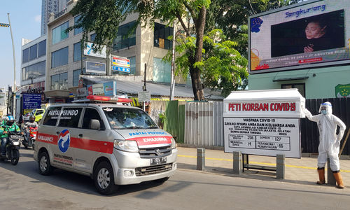 <p>Mobil ambulance melintas di dekat Tugu peti jenazah korban Covid-19 dan medis mengenakan hazmat terpajang di pertigaan Jalan Kemang 1, Jakarta Selatan, Sabtu, 15 Agustus 2020. Tugu tersebut dipajang untuk memberikan peringatan kepada warga untuk tetap waspada terhadap penyebaran Covid-19 yang masih menunjukkan statistik peningkatan korban setiap harinya. Foto: Ismail Pohan/TrenAsia</p>

