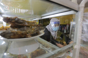 <p>Penjual menggunakan masker dan faceshield saat melayani pelanggan di Warung Tegal (Warteg) Ellya, Cilandak Timur, Jakarta Selatan, Rabu, 5 Agustus 2020. Pemilik warteg mengaku tetap konsisten menerapkan protokol kesehatan pencegahan penyebaran Covid-19 sejak dimulainya masa PSBB transisi hingga saat ini, untuk memastikan keamanan pelanggan yang datang dengan mewajibkan penggunaan masker, menyediakan area cuci tangan, dan pembatasan jarak fisik di area warung tersebut. Foto: Ismail Pohan/TrenAsia</p>
