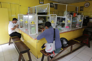 <p>Pelanggan menyantap makanan dengan suasana pembatasan jarak fisik di Warung Tegal (Warteg) Ellya, Cilandak Timur, Jakarta Selatan, Rabu, 5 Agustus 2020. Pemilik warteg mengaku tetap konsisten menerapkan protokol kesehatan pencegahan penyebaran Covid-19 sejak dimulainya masa PSBB transisi hingga saat ini, untuk memastikan keamanan pelanggan yang datang dengan mewajibkan penggunaan masker, menyediakan area cuci tangan, dan pembatasan jarak fisik di area warung tersebut. Foto: Ismail Pohan/TrenAsia</p>
