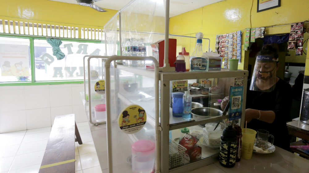 <p>Penjual menggunakan masker dan faceshield saat melayani pelanggan di Warung Tegal (Warteg) Ellya, Cilandak Timur, Jakarta Selatan, Rabu, 5 Agustus 2020. Pemilik warteg mengaku tetap konsisten menerapkan protokol kesehatan pencegahan penyebaran Covid-19 sejak dimulainya masa PSBB transisi hingga saat ini, untuk memastikan keamanan pelanggan yang datang dengan mewajibkan penggunaan masker, menyediakan area cuci tangan, dan pembatasan jarak fisik di area warung tersebut. Foto: Ismail Pohan/TrenAsia</p>
