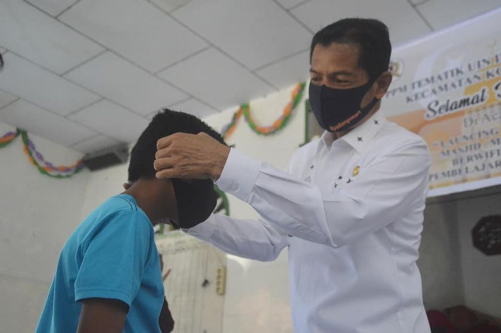 Kepala Diskominfo Padang, Rudy Rinaldy memakai masker kepada salah seorang pelajar di Padang/Foto: ist