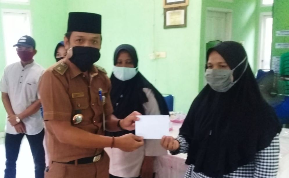 Lurah Bangsal Aceh Kecamatan Sungai Sembilan, Kota Dumai, Parlen Julianto menyerahkan bantuan beasiswa dari PT Semen Padang kepada perwakilan orangtua atau walimurid penerima beasiswa/Foto: ist