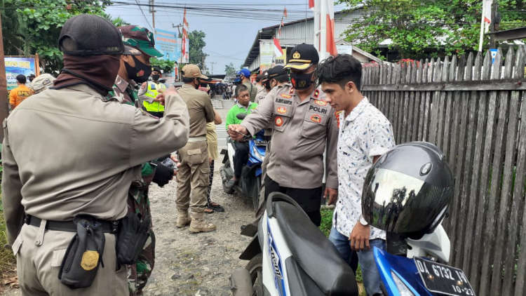 petugas Satpol PP menegur pria yang tidak menggunakan masker