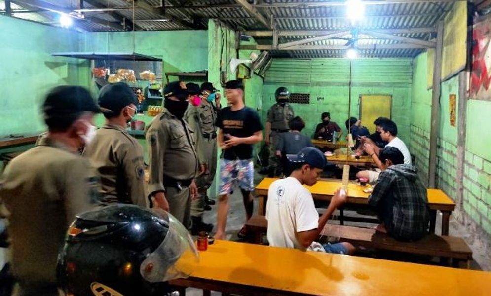 Satpol PP Surabaya melakukan razia di sebuah warung kopi