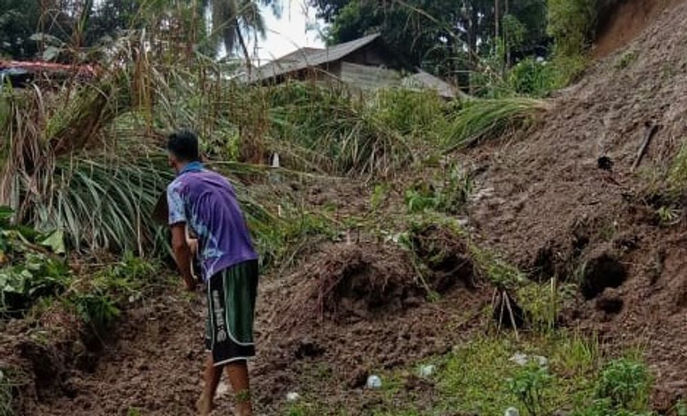 Seorang warga tengah membersihkan material longsir yang terjadi di  Kecamatan Sungai Geringging, Padang Pariaman/Foto: hantaran.co