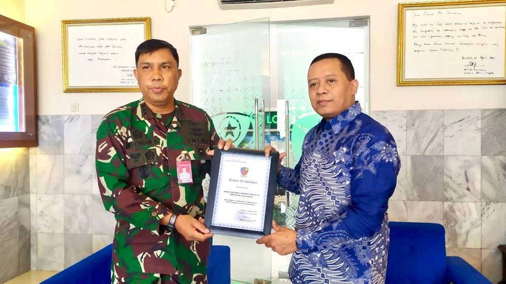 Komandan Lanud Kolonel Nav I Nyoman Suadnyana saat menyerahkan penghargaan pada Anthony di Markas Lanud Adi Sumarmo.